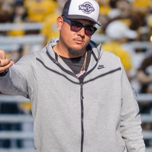 Jaime Medina on the field coaching kicking and punting specialists
